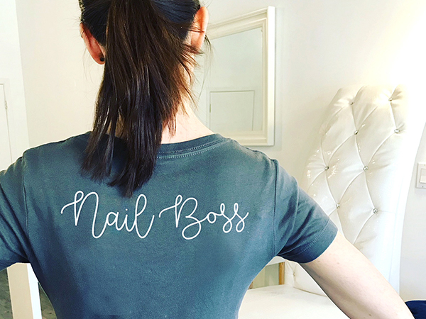 Boss Beauty Bar staff standing with back to camera. Shirt says Nail Boss